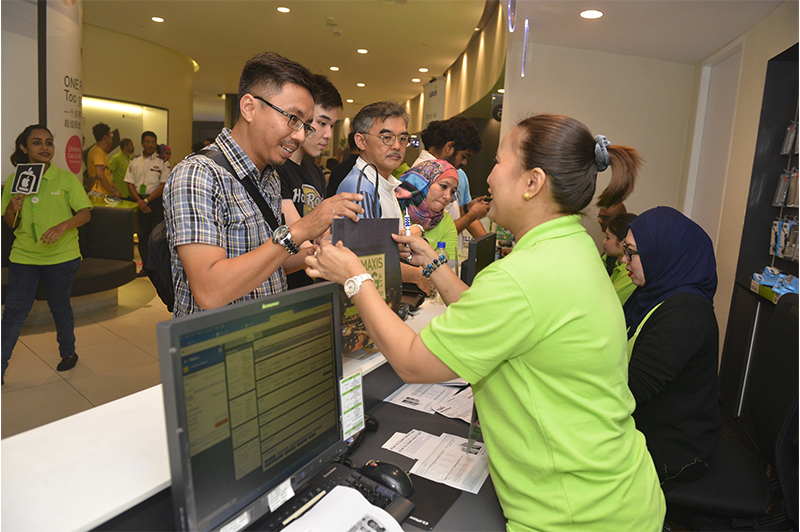 Mohd Nazrul Abdul Muttalib (left) was the first Maxis customer to collect his iPhone 6s Plus at the KLCC Maxis Centre at midnight.